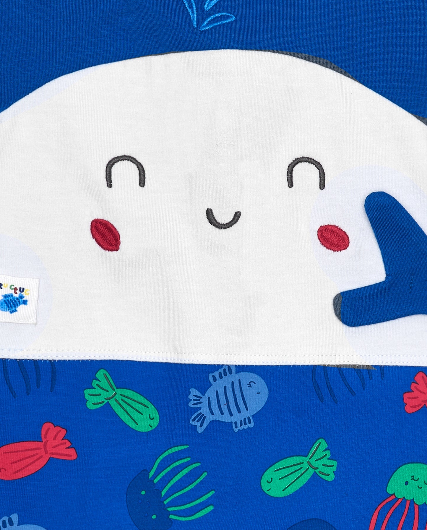 Children's romper with a whale character on a blue background